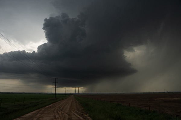 A supercell thunderstorm with a rotating wall cloud over the open plains.